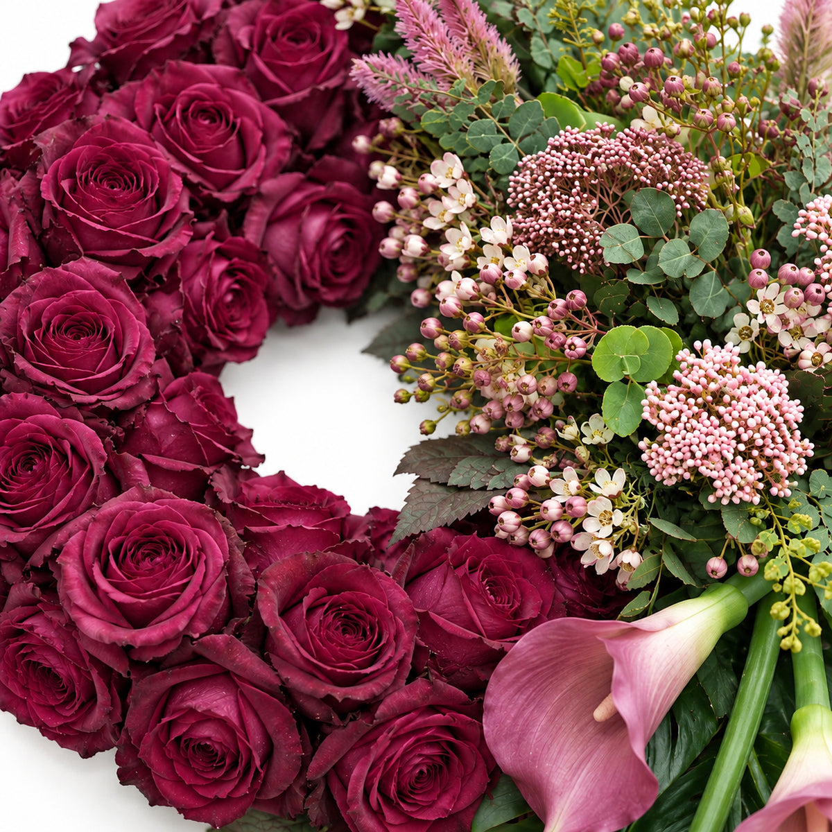 Detail van pruimkleurige rozen, roze bloemen en calla