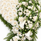 Detail van witte rozen en bloemen in het rouwhart
